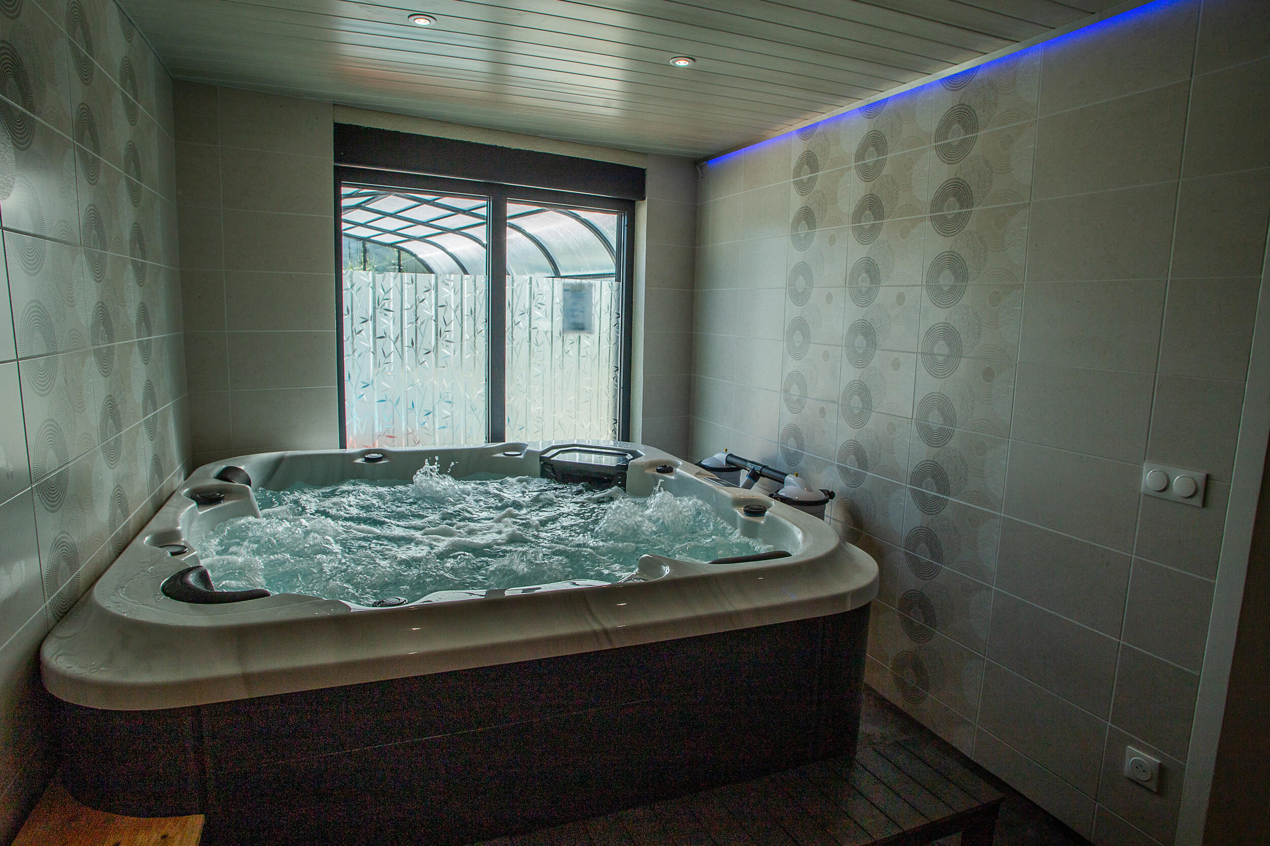 Espace détente avec sauna et jacuzzi au camping du Lac de Paladru 2 Jacuzzi à hydromassage cinq places de l'espace détente avec éclairage LED bleuté